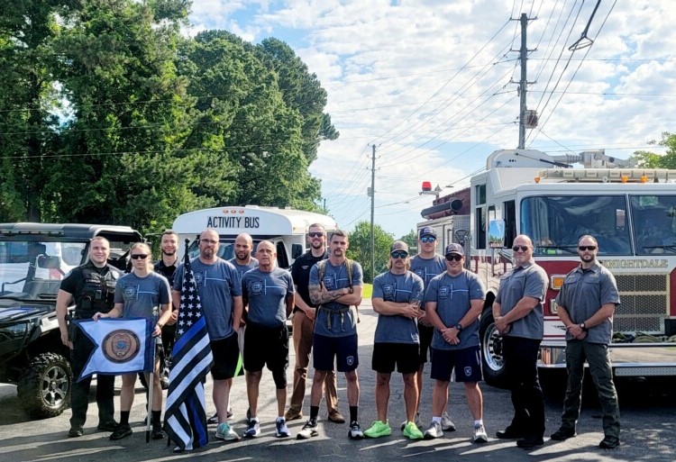 Law Enforcement Torch Run for Special Olympics participants stand in front of Knightdale Fire truck and activity bus